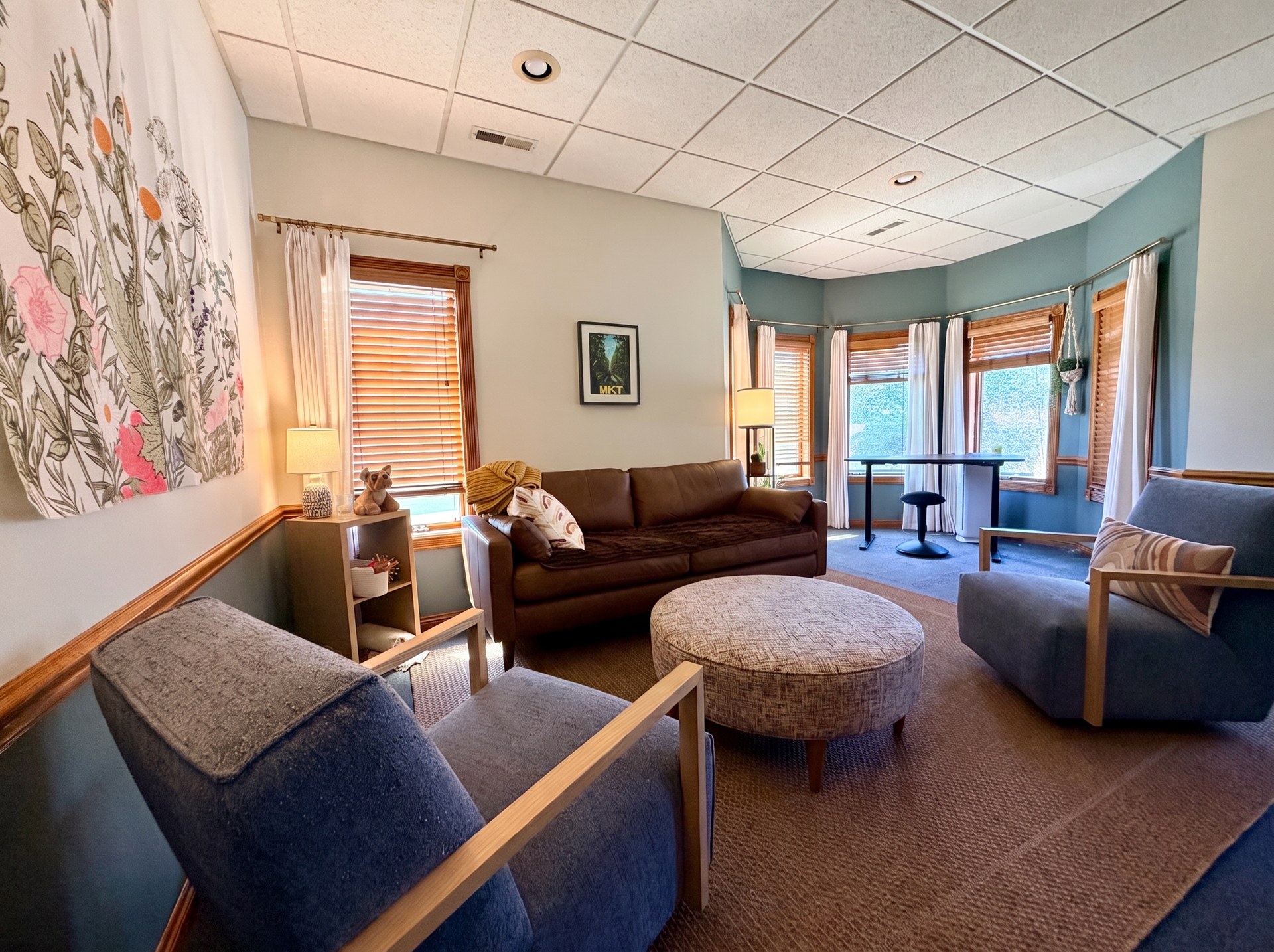 A calm, welcoming therapy office with cozy seating, plants, and soft natural light.